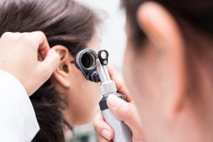 HNO untersucht gerade das Ohr einer Patientin zur Abklärung möglicher Erkrankungen