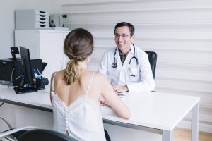 Männlicher Arzt mit weiblicher Patientin im Arztgespräch