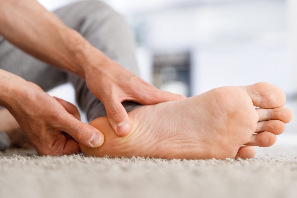 Patient greift sich an Ferse
