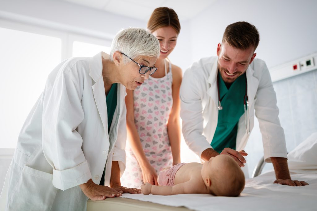 Arzt untersucht Baby im Zuge der Mutter Kind Pass Untersuchung