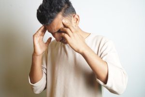 Mann leidet an Spannungskopfschmerzen