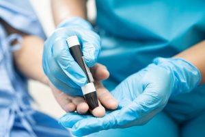 Arzt überprüft Blutzuckerspiegel bei Diabetes Patient